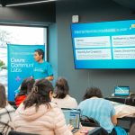 Pessoa apresenta ferramentas de tecnologia durante um workshop para participantes.