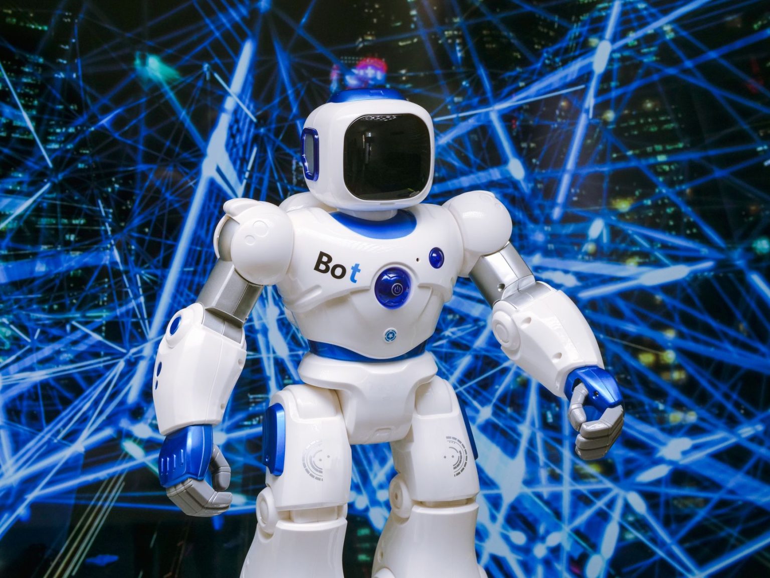 Robô humanoide com detalhes luminosos azuis diante de uma rede digital, em uma representação conceitual de automação e tecnologia.