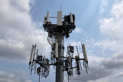 Torre de telecomunicações equipada com diversas antenas sob um céu nublado.