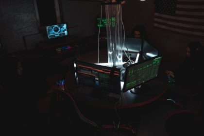 Equipe de especialistas em cibersegurança trabalhando em conjunto diante de computadores em uma sala escura
