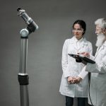 Pesquisadores trabalham com tecnologia robótica avançada em um laboratório.