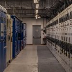 Sala de controle industrial com painéis elétricos e equipamentos de monitoramento.